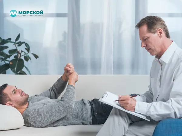 Мужчина рассказывает психотерапевту о своих проблемах лежа Пациент лежит на приеме у психолога