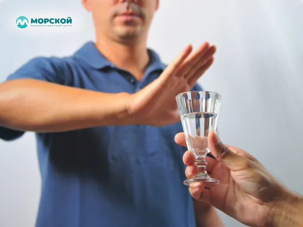 Мужчина отодвигает руку человека который предлагает ему алкоголь Мужчина отказывается от алкоголя